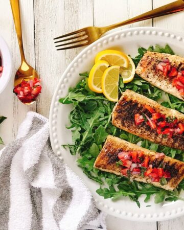 grilled mahi mahi on white plate topped with strawberry salsa