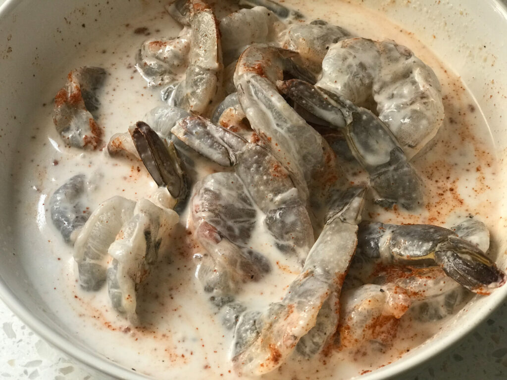 Raw shrimp in a bath of seasoned coconut milk.