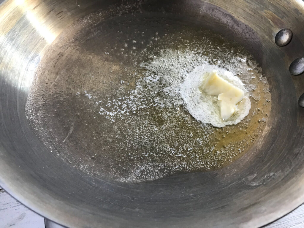 Melted butter and extra virgin olive oil in a silver frying pan