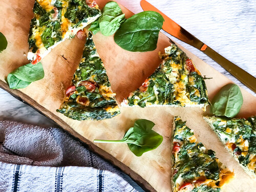 Spinach, Tomato, and Cheddar Frittata on a brown wooden cutting board | Keto, Low-Carb

