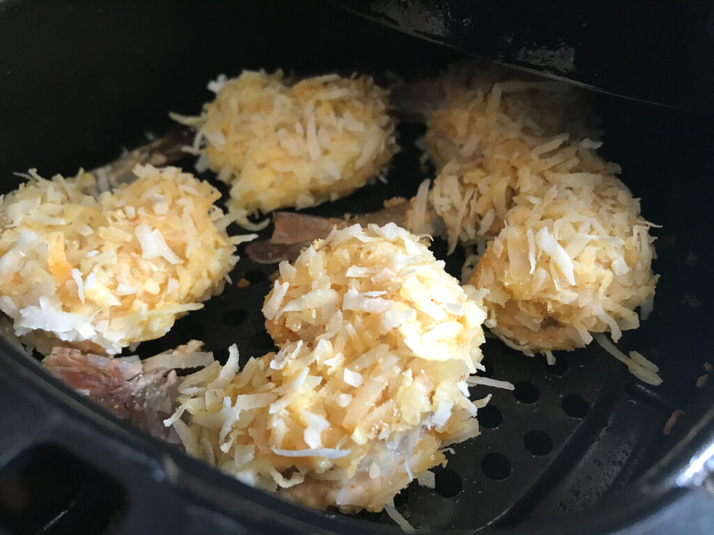 keto coconut shrimp in the air fryer basket prior to frying