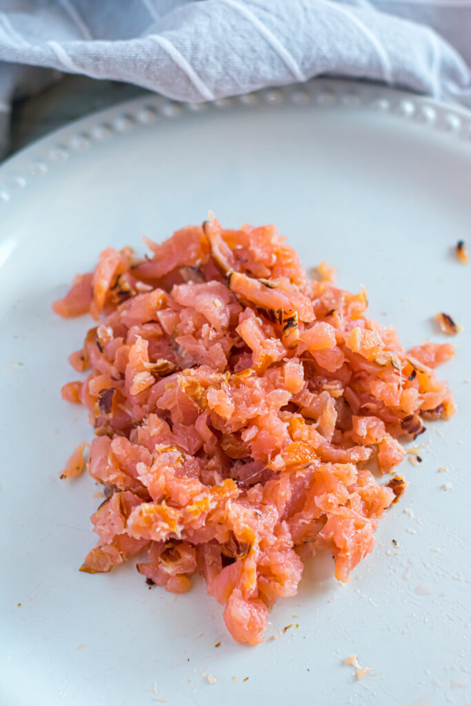 Chopped smoked salmon on a white plate.