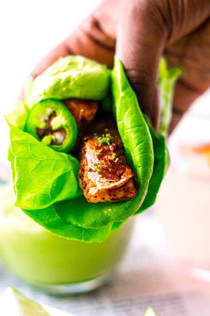 Blackened Salmon Lettuce Wraps being held in a brown hand.