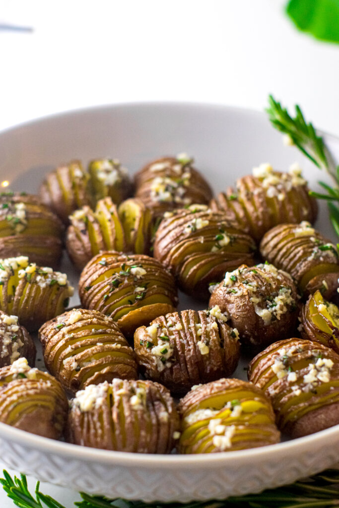 Hasselback baby red potatoes in a white bowl