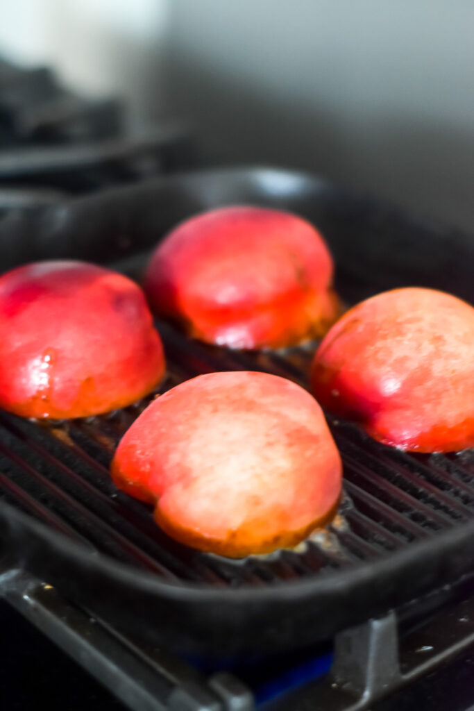 Peaches cooking on a cast iron grill pan. 