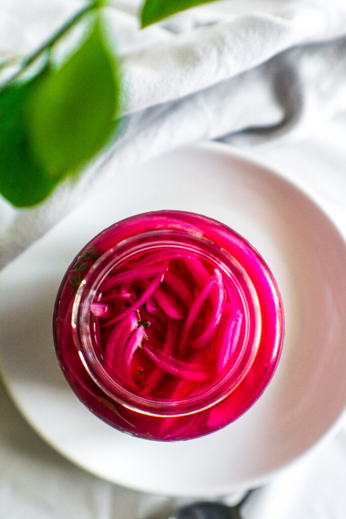 Pickled red onions in a glass jar.