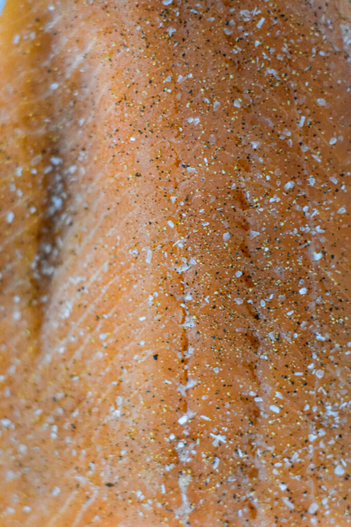 Raw salmon seasoned with salt and pepper.